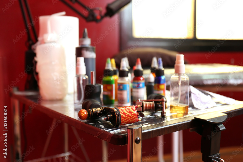 Parts of tattoo machine on wooden table, close up view Parts of tattoo machine on wooden table, close up view