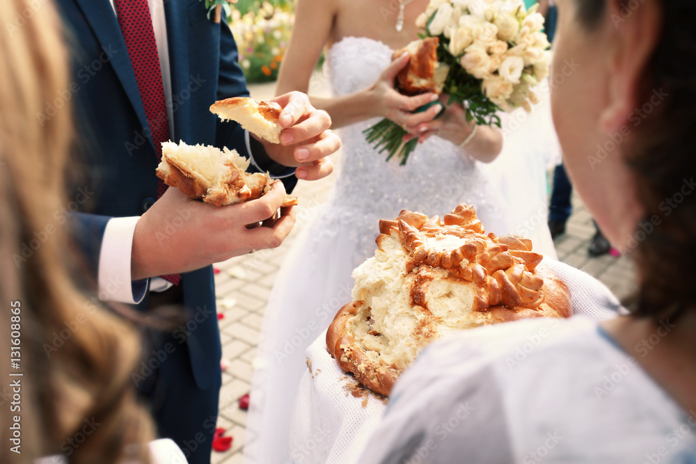 Traditional wedding bread with salt. Groom holding piece of bread