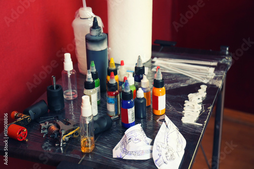 Tattoo master workplace with colorful inks and instruments, close up view