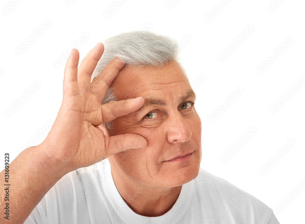 Senior handsome man examining his face on white background Senior handsome man examining his face on white background