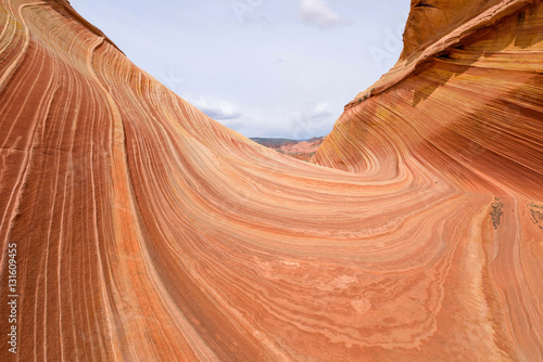 Red swirling sandstone rocks at The Wave - a dramatic erosional sandstone rock formation located in North Coyote Buttes area of Paria Canyon-Vermilion Cliffs Wilderness at Arizona-Utah border. 