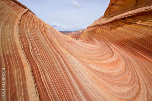 Colorful and swirling sandstone rock formations at The Wave - a dramatic erosional sandstone rock formation located in North Coyote Buttes area at Arizona-Utah border.