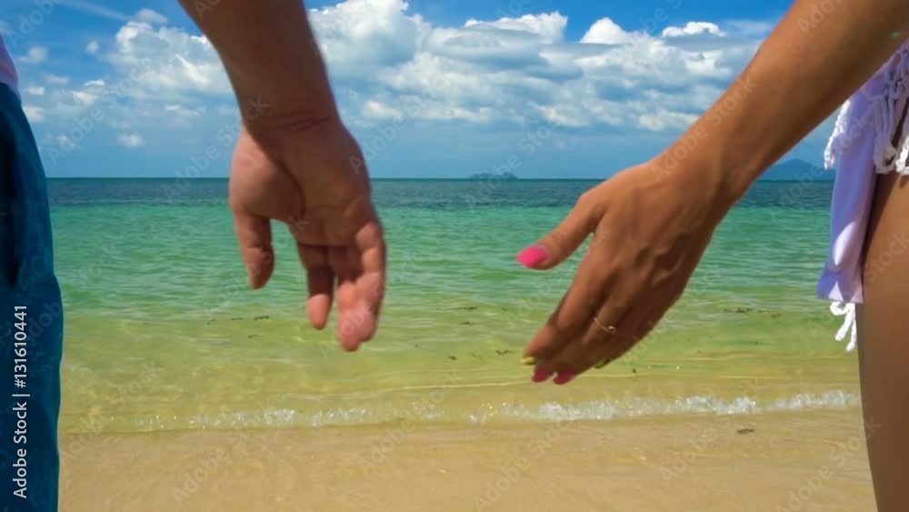 Romantic Couple Hold Hands on the Beach Romantic Couple Hold Hands on the Beach