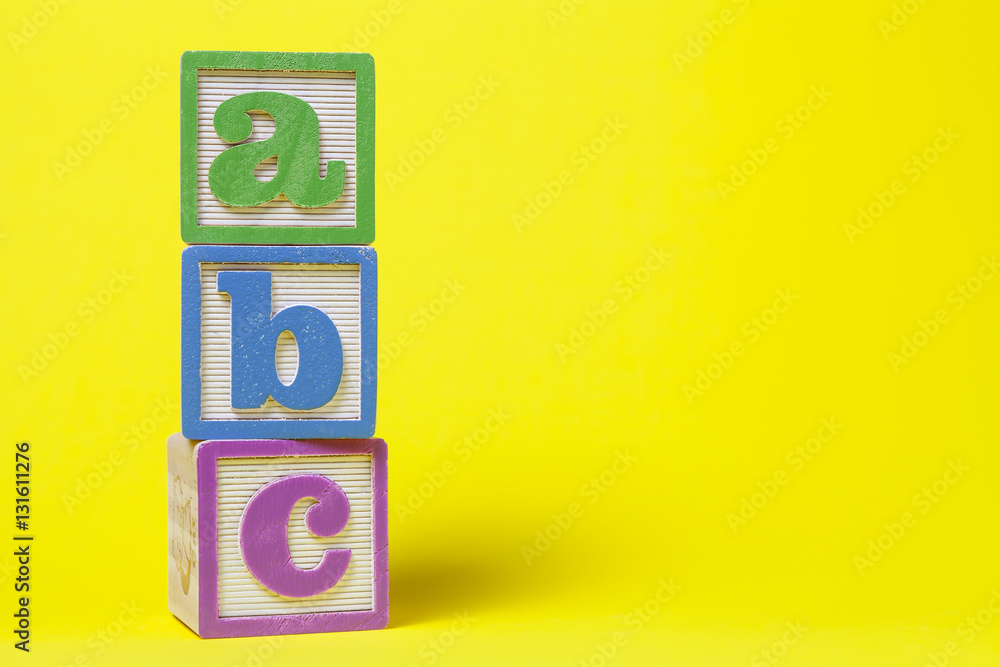 Abc Alphabet Blocks Stacked Up On Yellow Background Stock Photo Adobe