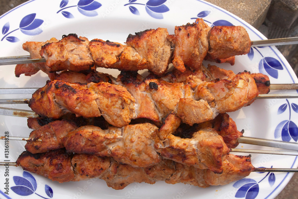 Grilled meat on skewers.Fresh grilled pork pieces on skewers close up ready for outdoor party.