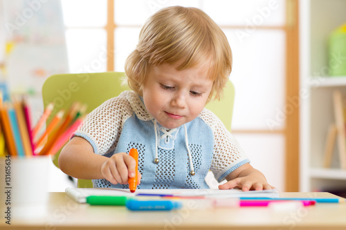 Cute little boy is drawing ...