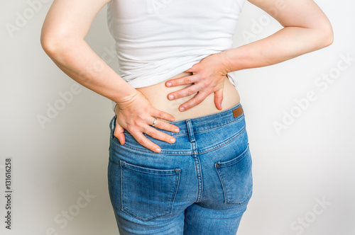 Woman with back pain holding her aching back © andriano_cz