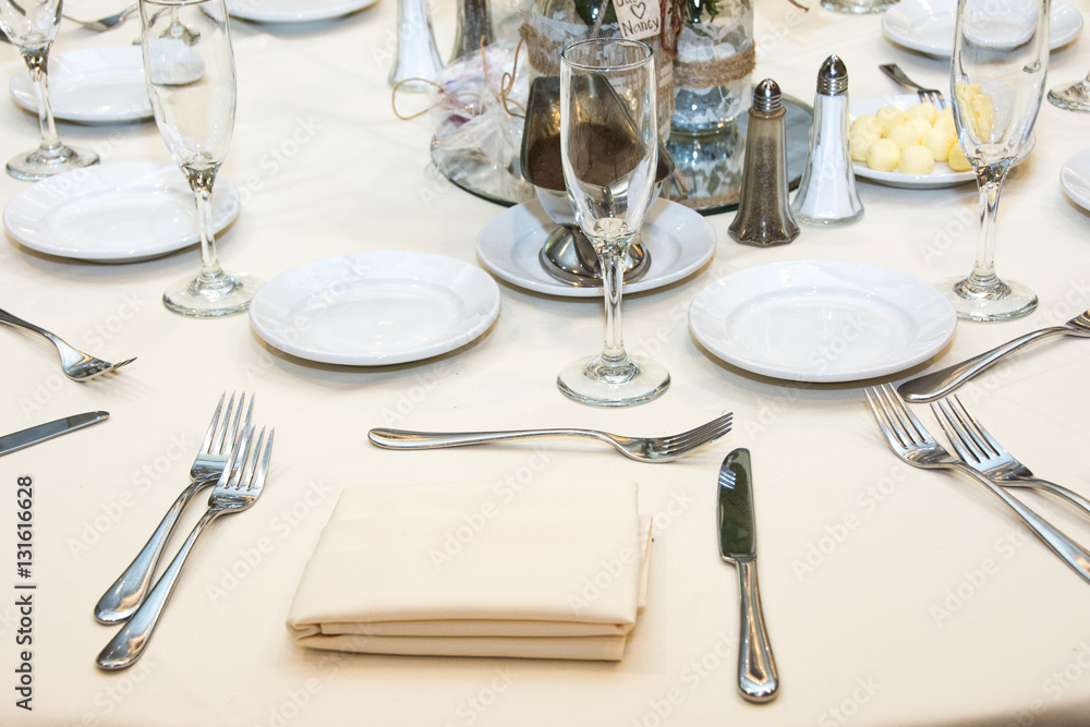 Fototapeta premium White table setting. Nife, fork, glass. Wedding decoration