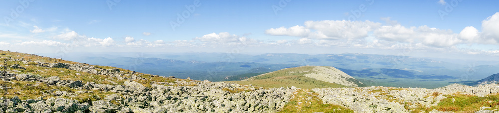Panoramic mountain landscape in a national park in sunny summer day. River of stones with moss and green grass around. Natural background for web site banner.