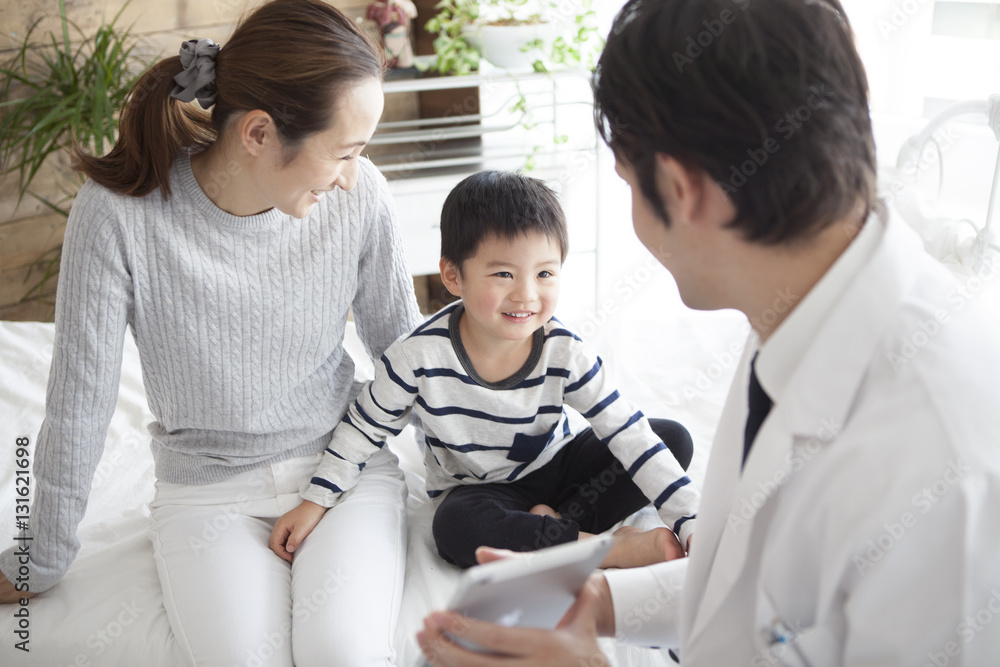 The doctor is showing the tablet to the boy The doctor is showing the tablet to the boy