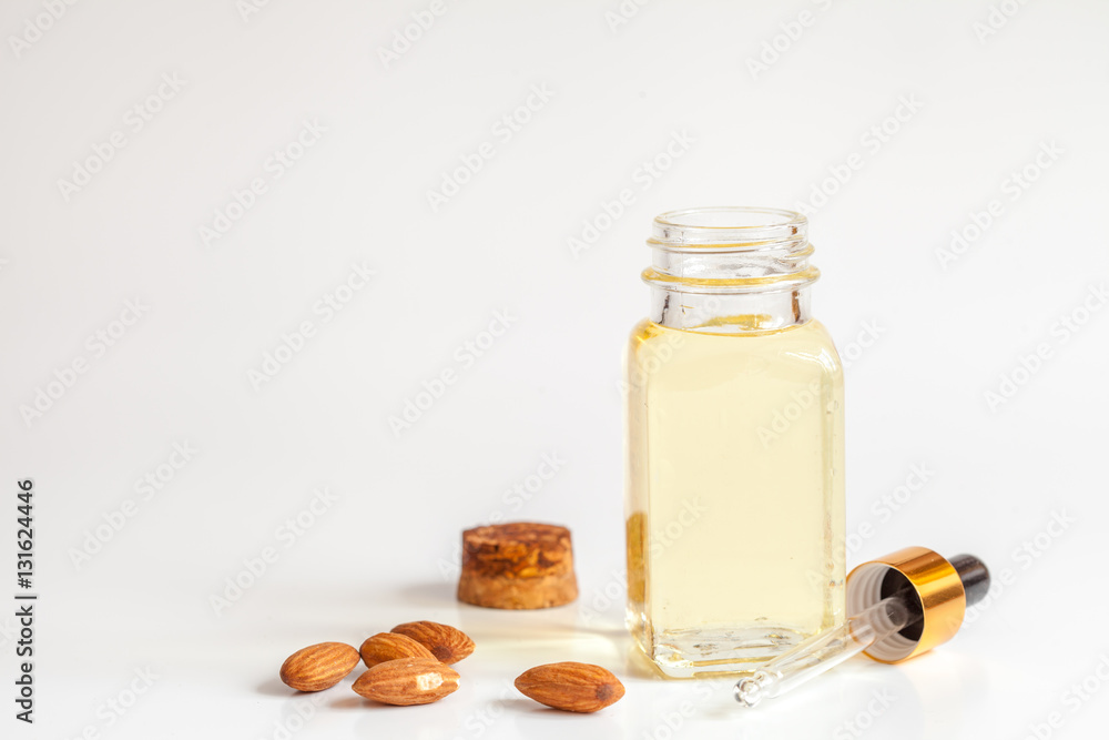 cosmetic almond oil in glass bottle on white background