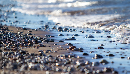 Foto pebbles among the sand on seashore. Close-up blur