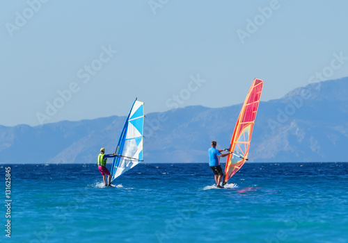Back view of two windsurfers in action mooving parallel to each other © vladimircaribb