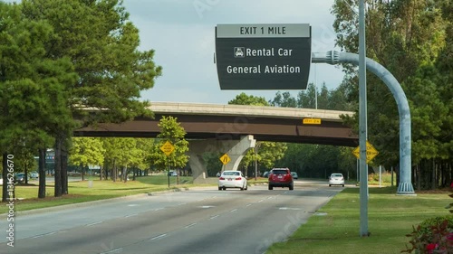 Cars Driving Into Houston George Bush Intercontinental IAH Airport Close up with Overhead Rental Car Signs photo