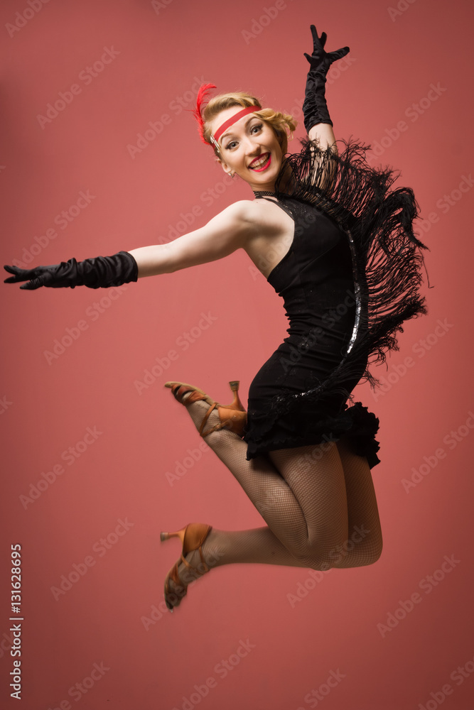Obraz premium Ładna aktorka w czarnej sukience retro tańczy Charleston