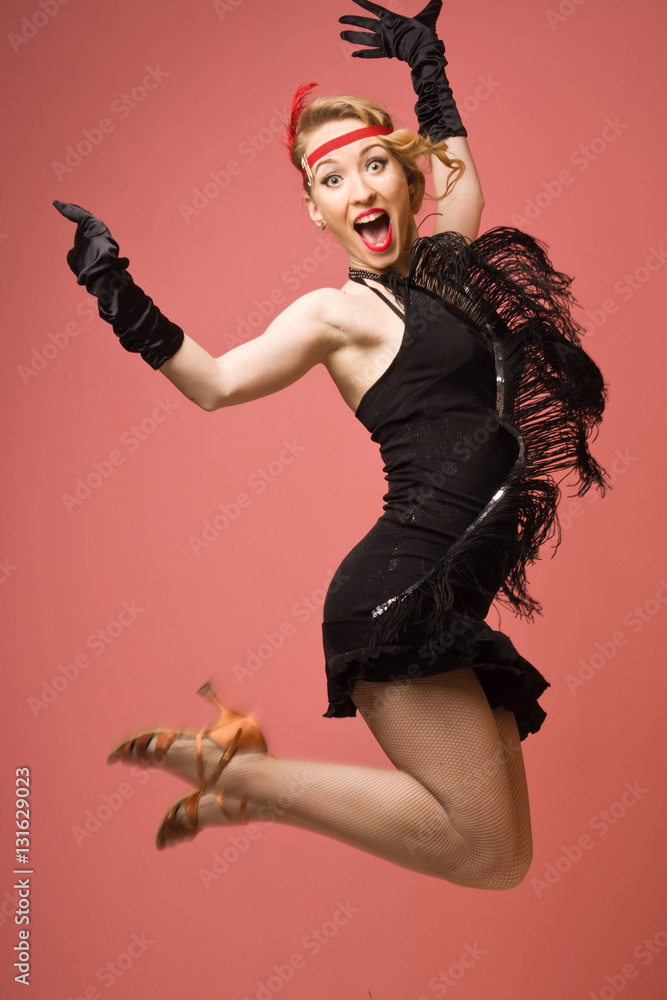 Naklejka premium Pretty actress in black retro dress dancing charleston
