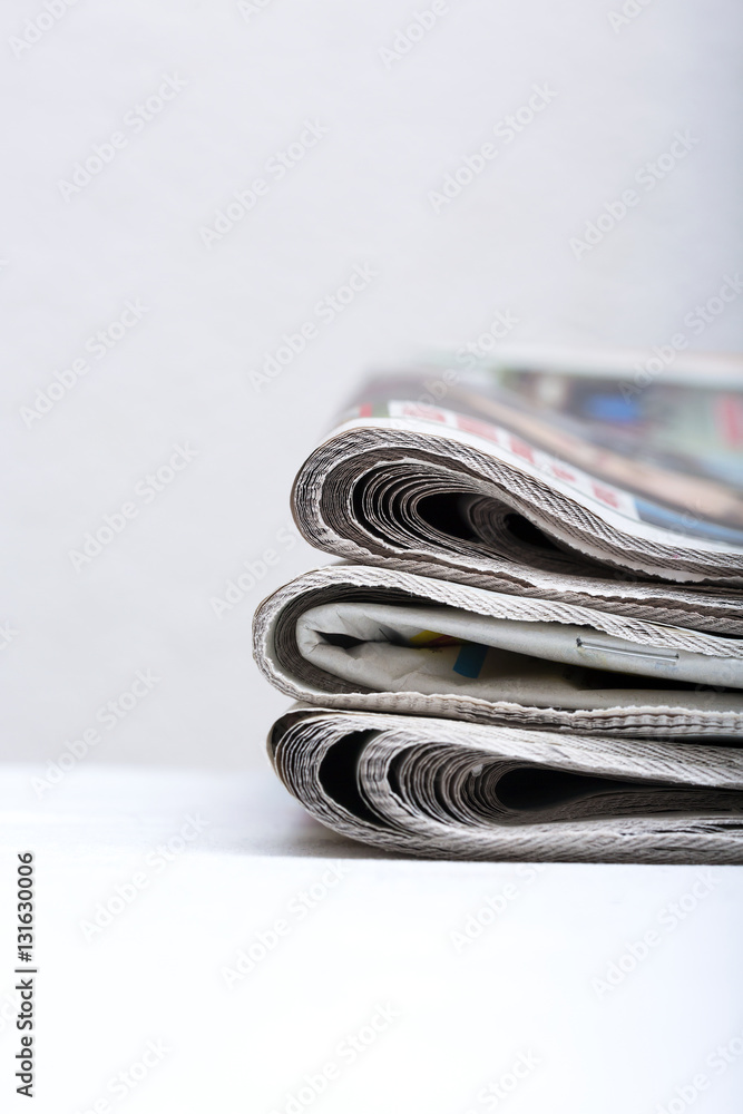 Pile of newspapers on a white table. Pile of newspapers on a white table.