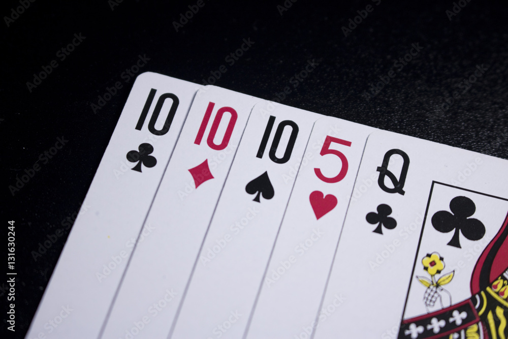 three of a kind poker card on dark black background