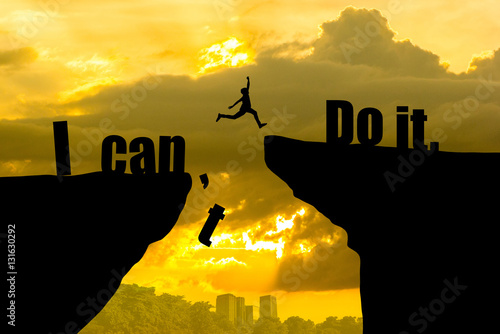 Man jumping on I can do it or I can't do it text over cliff on sunset background,Business concept idea