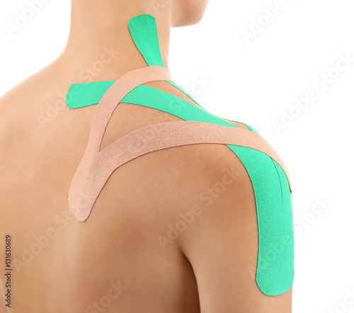 Female shoulder with physio tape on white background photo