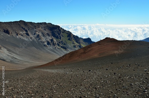 Looking down in the Haleakala Crater while clouds are being blown over the mountain ridge, Maui island, Hawaii