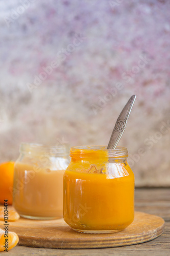 Glass jars with natural baby food on the wooden table