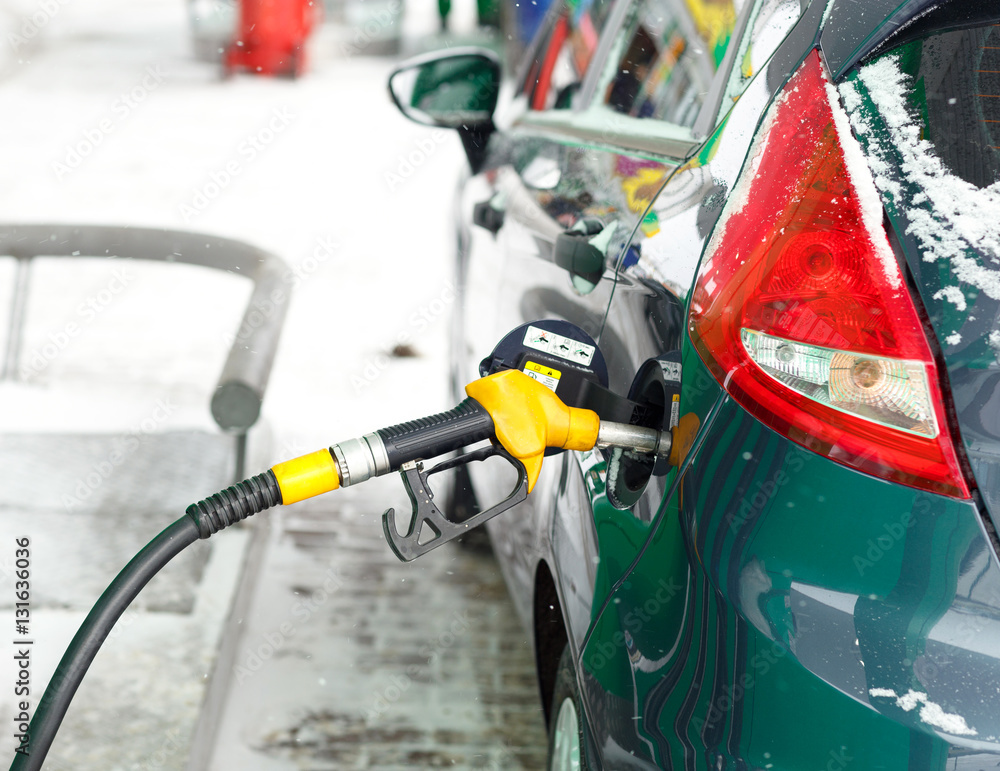 Fototapeta premium Car refueling on a petrol station in winter close up