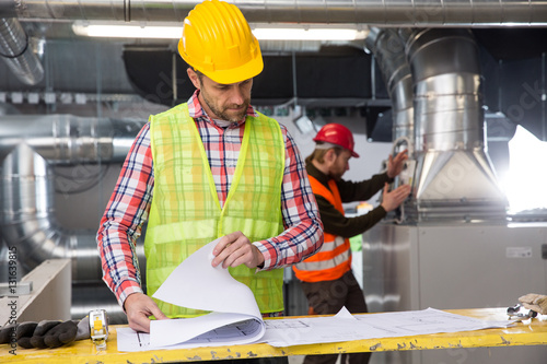 Portrait of a worker, constructing and checking development of a small business hall. Reliable civil engineer working on a construction site, foreman at work