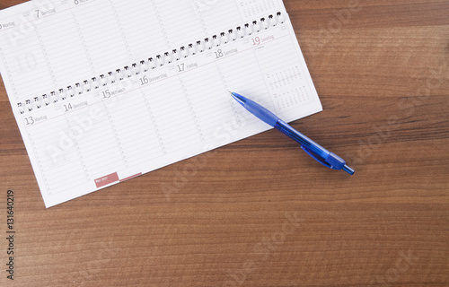 Arbeitsplatz im Büro, Schreibtisch mit Kalender, Stift, Papier, photo