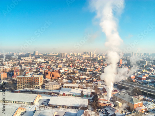Winter town. Frosty sunny day in the city. Snow on the streets and smoke from the boiler rises. Frost and sun  a wonderful day