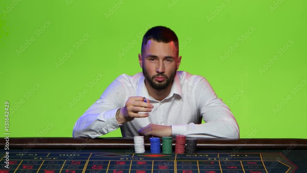 Man turns the chip between his fingers. Place your bets Man turns the chip between his fingers. Place your bets