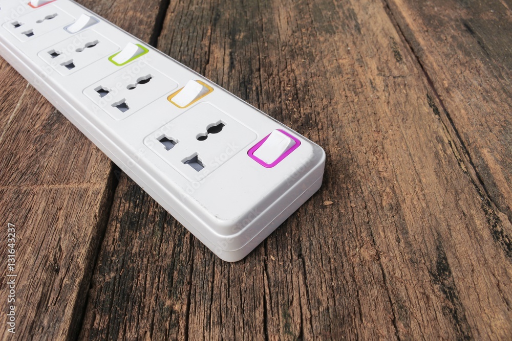 white plug socket electric power bar or extension block on wood background white plug socket electric power bar or extension block on wood background