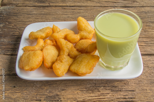 Foto green soybean milk and deep-fried doughstick on wood background