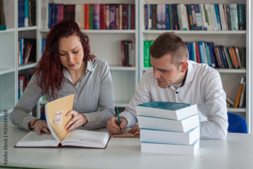 Beautiful redhead girl and handsome blond guy working on a proje Beautiful redhead girl and handsome blond guy working on a proje