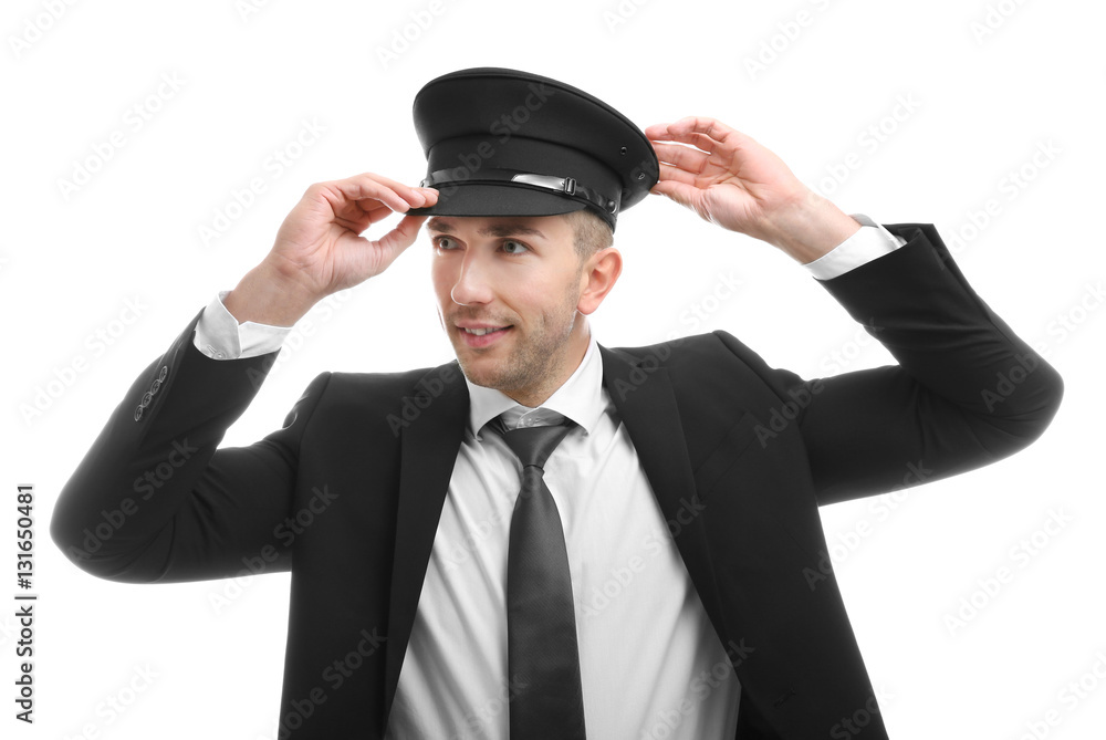 Young chauffeur adjusting his hat on white background Young chauffeur adjusting his hat on white background