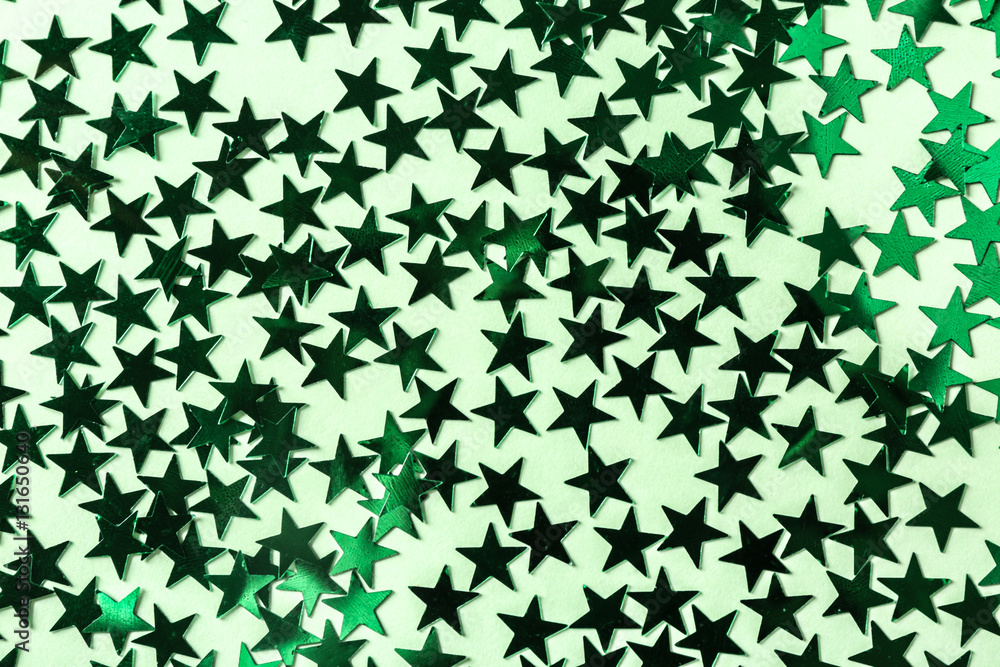 Bright confetti in shape of stars, on green background. Close up Bright confetti in shape of stars, on green background. Close up