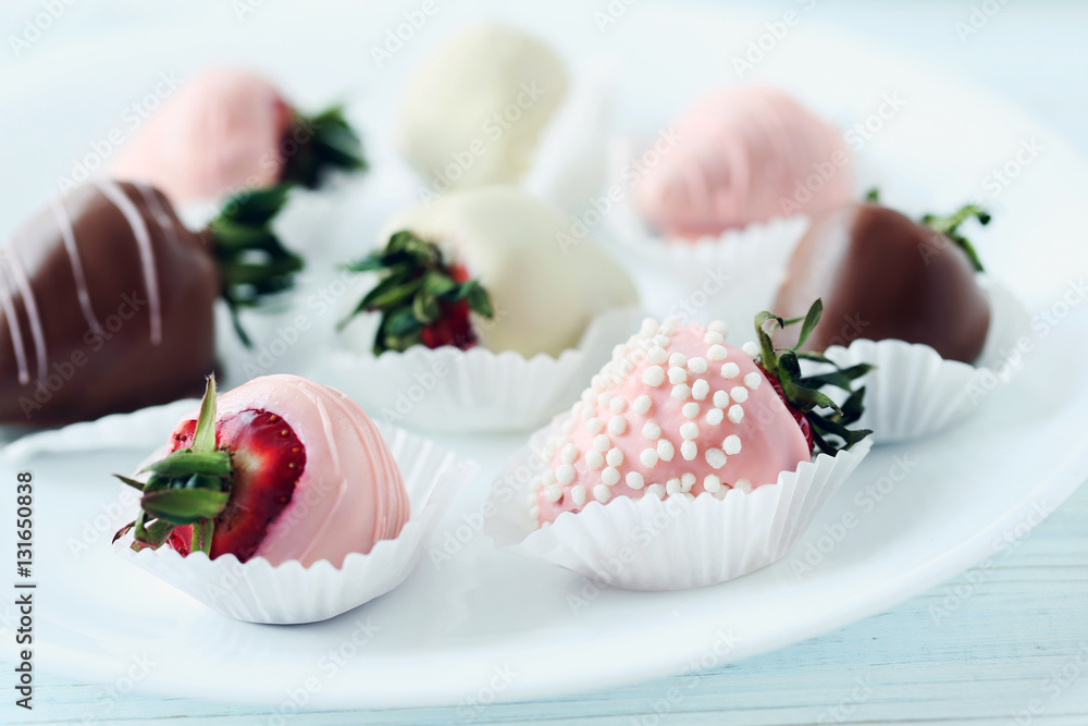 Strawberries covered in chocolate on a blue wooden table Strawberries covered in chocolate on a blue wooden table
