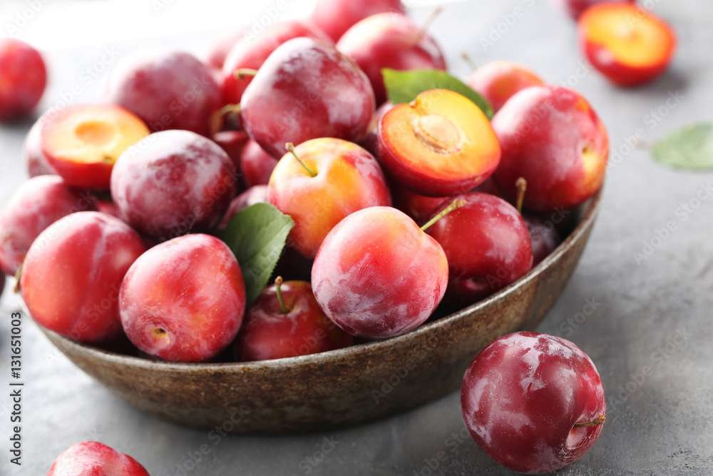 Fresh plums on a grey wooden table Fresh plums on a grey wooden table
