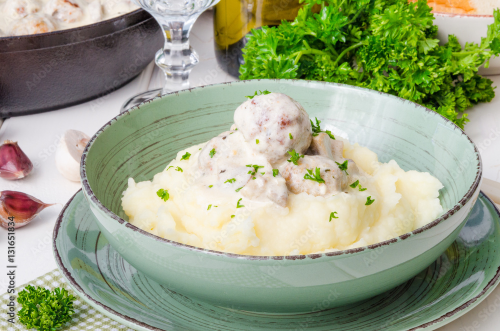 Meatballs in a creamy sauce with mushrooms and mashed potatoes in a plate Meatballs in a creamy sauce with mushrooms and mashed potatoes in a plate