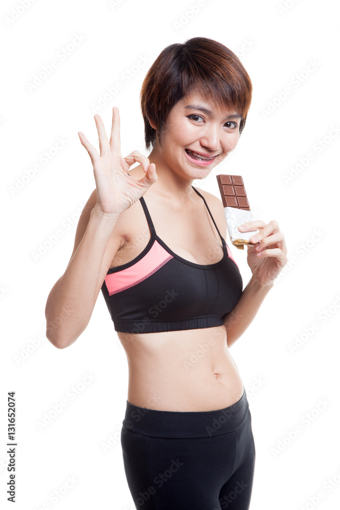 Beautiful healthy Asian girl show OK with chocolate. Beautiful healthy Asian girl show OK with chocolate.