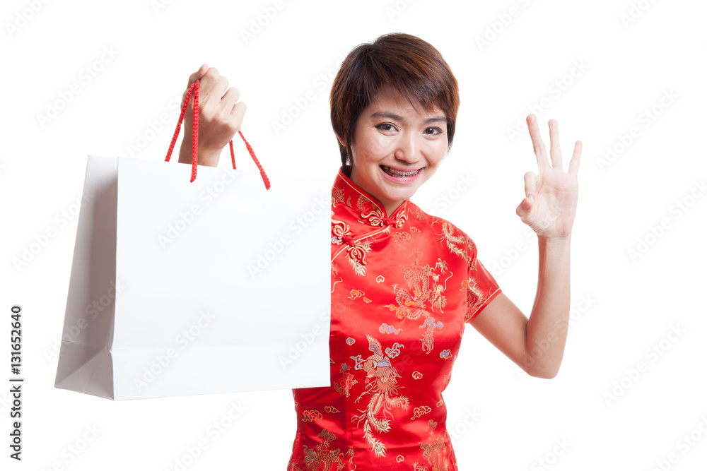 Asian girl in chinese cheongsam dress with shopping bag. Asian girl in chinese cheongsam dress with shopping bag.