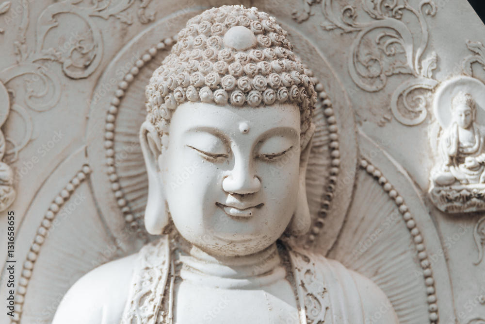 Sculpture of Buddha in a white stone fountain