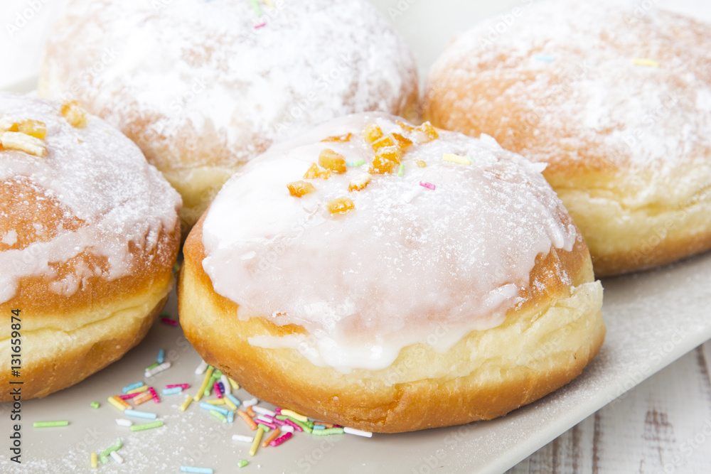 donuts with frosting and powdered sugar on a platter donuts with frosting and powdered sugar on a platter