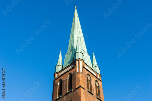 Kirchturm mit Kupferdach bei blauem Himmel