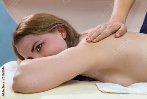 Woman at spa salon. Closeup of a beautiful young woman getting back massage at a spa salon.