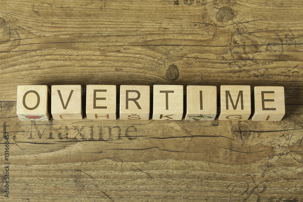 overtime word on cubes on wooden background