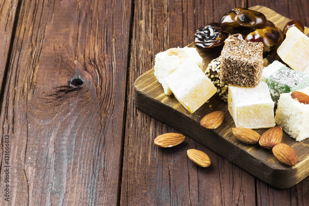 Oriental sweets, dates and nuts on a dark wooden background. Cop Oriental sweets, dates and nuts on a dark wooden background. Cop