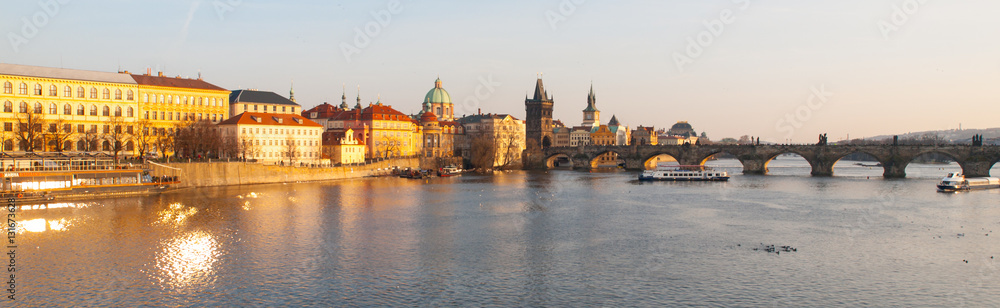 Prague Evening. Towers of Old Town and Charles Bridge over Vltava River illuminated by orange sunset. UNESCO World Heritage Site. Prague, capital city of Czech Republic, Europe. Panoramic view.