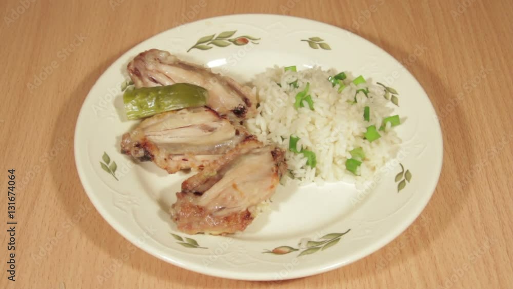 Man creates dishes portion from chicken wings with rice. Man creates dishes portion from chicken wings with rice.