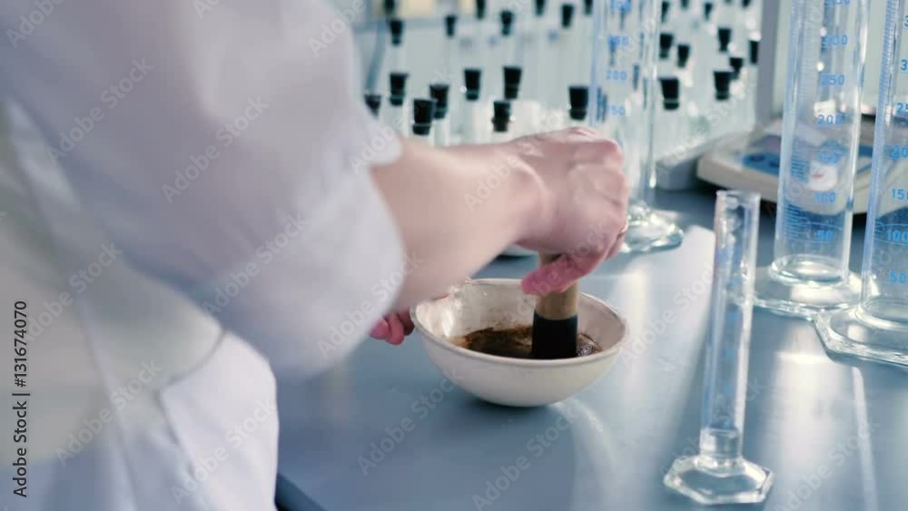 Worker mixing medications in a bowl. Worker mixing medications in a bowl.